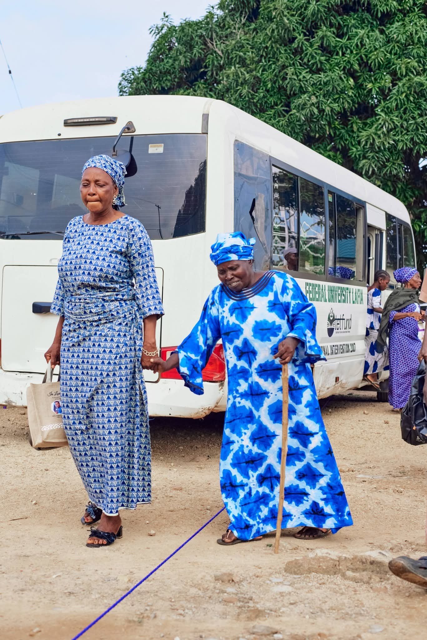Two women arrive beside a medical outreach bus.