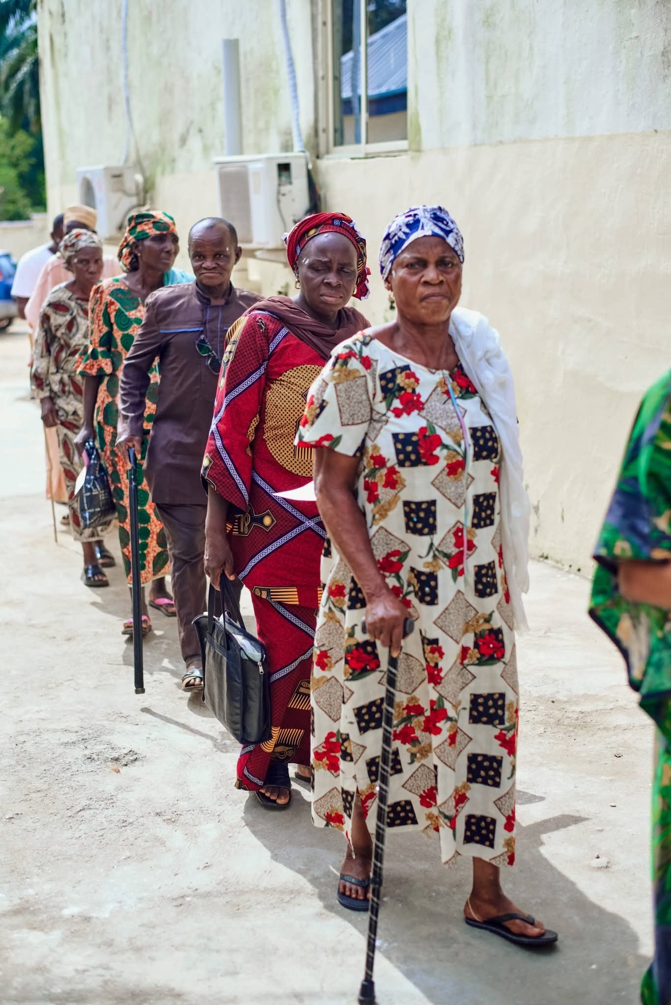 Community members standing in line outside a clinic.