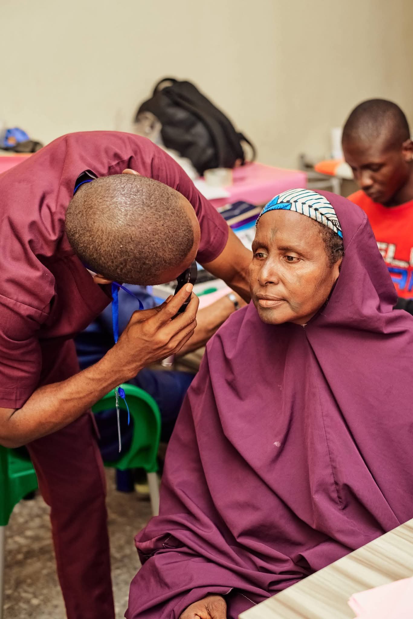 Volunteer clinician examining a woman’s eye.