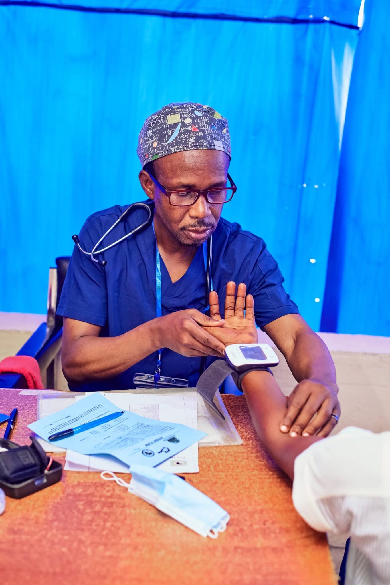 A clinician takes a participant’s blood pressure.