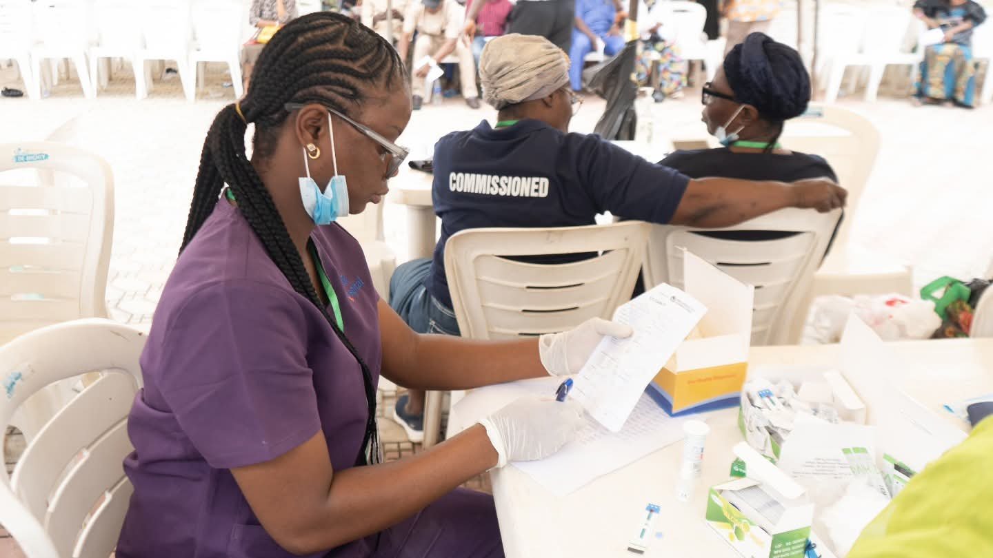A volunteer reviews paperwork at an outreach service desk.