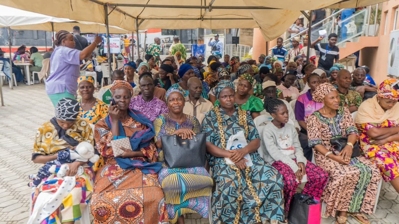 Community members seated beneath a canopy during the UBOMI outreach.
